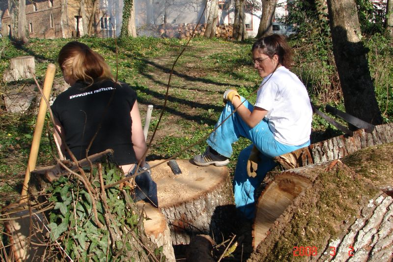 Anna and Juliana rest from raking and carrying debris to the fire.